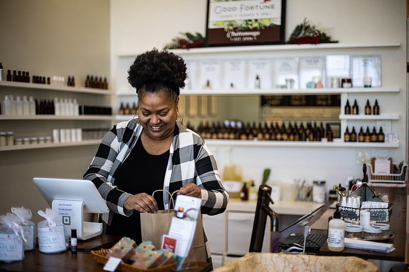 Staff photo by Troy Stolt / Good Fortune Soap and Spa manager Angie King helps a customer choose the right essential oil, all of which are plant-based and therapeutic grade.