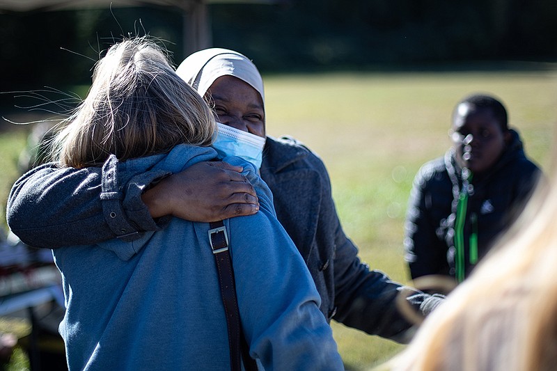 Staff photo by Troy Stolt / Randa Letim, who moved to the U.S. from Sudan, embraces her friend during Culture Chatt's monthly festival, helping spotlight different cultures in the community.