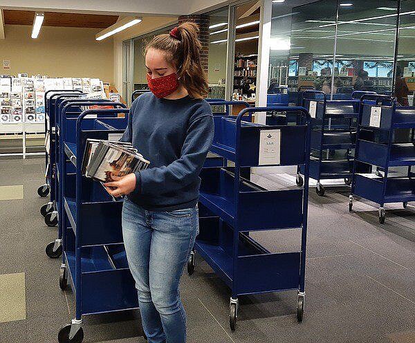 Charles Oliver/Daily Citizen-News / Technology Lab Center Library Assistant Rachael Lezcano Perez gathers DVDs to return to the shelves earlier this month at the Dalton-Whitfield County Public Library.