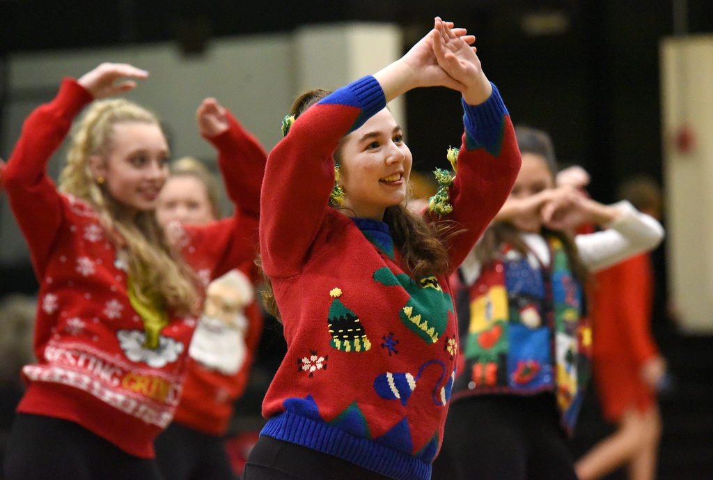 Staff Photo by Matt Hamilton / Alex Loyd, front, dances with the Irish Charms dance team as they perform a routine dressed in Christmas sweaters during halftime of the Notre Dame High School basketball game against Baylor on Friday, December 17, 2021.