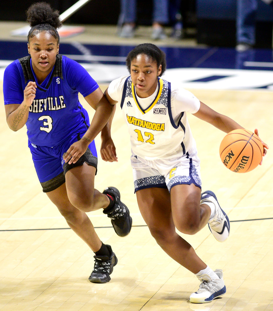 Staff Photo by Robin Rudd / UTC's Destiny McClendon (12) brings the ball up court past Asheville's Jamia Blake (3). The University of Tennessee at Chattanooga Mocs hosted the University of Asheville in NCAA women's basketball at McKenzie Arena on December 20, 2021.