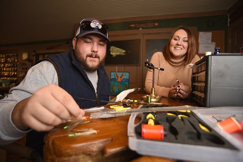 Staff Photo by Matt Hamilton / Bethany McCoy looks on as Caleb Luzader ties a fly at Ranger Outdoors in Charleston, Tenn. on Tuesday, November 23, 2021. 