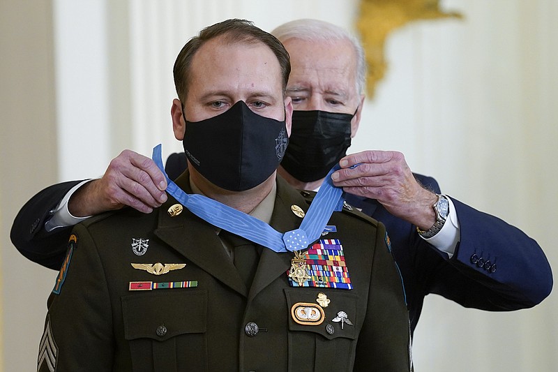 President Joe Biden presents the Medal of Honor to Army Master Sgt. Earl Plumlee for his actions in Afghanistan on Aug. 28, 2013, during an event in the East Room of the White House on Dec. 16, 2021.