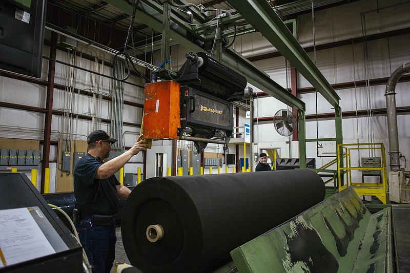 Contributed photo by Propex / Propex employees Mike Cook, left, and Adam Brock work on the production line at the company's manufacturing plant in Ringgold, Georgia. Solmax acquired Propex last month and company officials hope to grow their geotextile products for erosion control and other uses with growing infrastructure investment and focus on climate change.