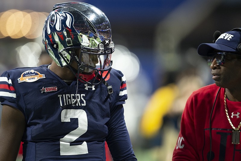 Jackson State head coach Deion Sanders talks with son Jackson State quarterback Shedeur Sanders (2) before the Cricket Celebration Bowl NCAA college football game against the South Carolina State Saturday, Dec. 18, 2021, in Atlanta. (AP Photo/Hakim Wright Sr.)