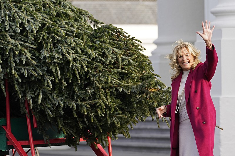 AP Photo/Susan Walsh / First lady Jill Biden waves to onlookers as she eyes the official White House Christmas Tree, grown in North Carolina, as it arrives at the White House in Washington in November.