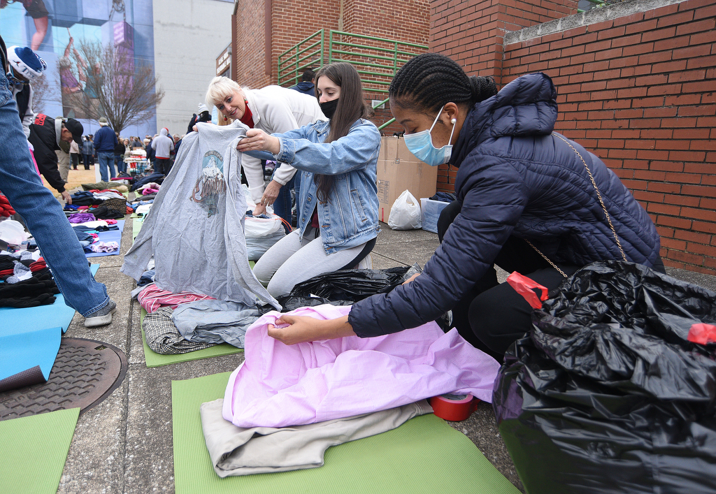 Staff Photo by Matt Hamilton / Cathleen Laskowski, back, Kelly Nel, and De'Jha Billingsley, front, lay out clothing to be given away at the Bessie Smith Cultural Center on Friday, December 24, 2021.