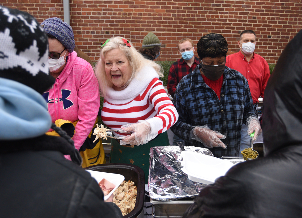 Staff Photo by Matt Hamilton / From left, Merry Brown, Debbie Rodriguez and Sabrina Bell give out food at the Bessie Smith Cultural Center on Friday, December 24, 2021.