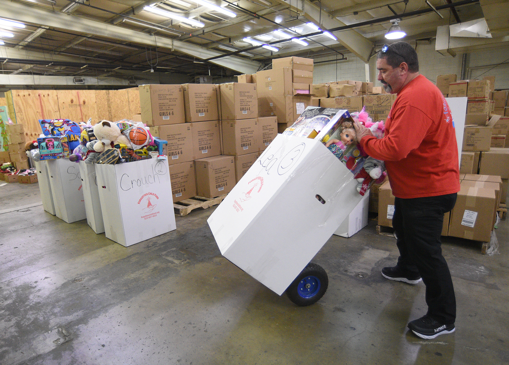 Staff Photo by Matt Hamilton / Robert Baty moves a box of toys to be loaded on a truck at the Forgotten Child Fund warehouse on Friday, December 24, 2021.