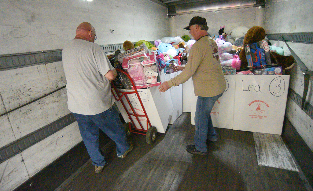 Staff Photo by Matt Hamilton / Brett Hall, right, helps Dr. Troy Smith as they load a box of toys on a truck at the Forgotten Child Fund warehouse on Friday, December 24, 2021.