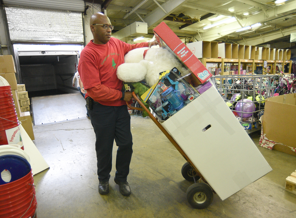 Staff Photo by Matt Hamilton / Jeffery Evans moves a box of toys to be loaded on a truck at the Forgotten Child Fund warehouse on Friday, December 24, 2021.