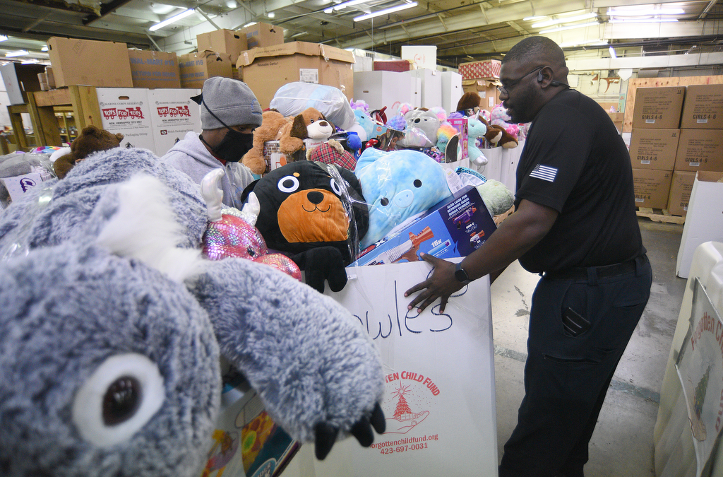 Staff Photo by Matt Hamilton / Steven Wilson, left, and Sgt. David Young load boxes on a truck at the Forgotten Child Fund warehouse on Friday, December 24, 2021.