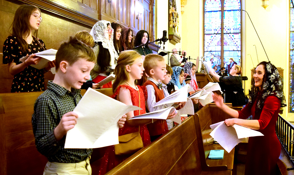 Staff Photo by Robin Rudd / Maria Rist, right, directs the Jubilate Deo Youth Schola in a musical prelude before the service. The Vigil Mass of Christmas was celebrated at the Basilica of Saints Peter and Paul on December 24, 2021.