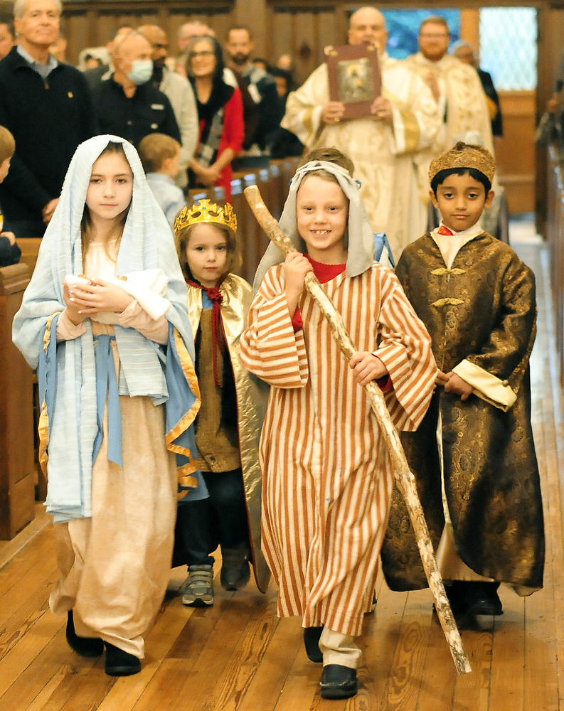 Staff Photo by Robin Rudd / Sarah Stradley, portrays Mary as she carries the infant Jesus and Nate St. Pierre is Joseph. Processing in the background are the Three Kings. The Vigil Mass of Christmas was celebrated at the Basilica of Saints Peter and Paul on December 24, 2021.