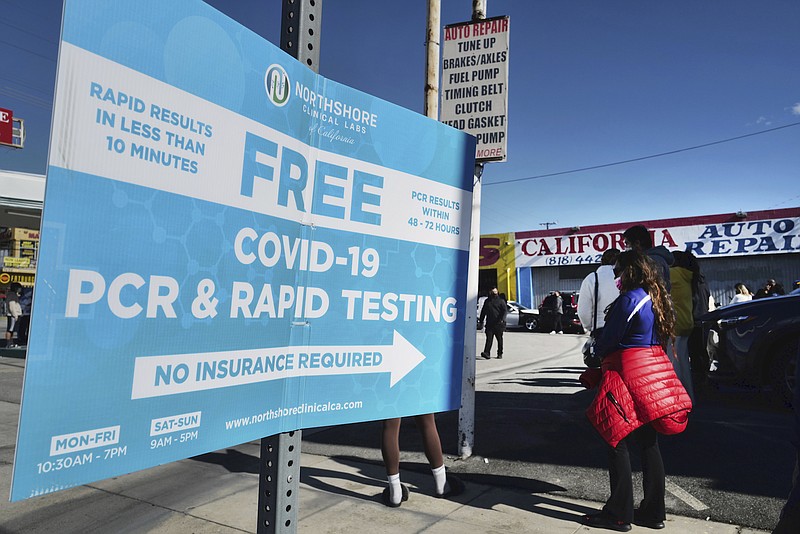 Photo by Richard Vogel of The Associated Press / People line up for a free COVID-19 rapid test at a gas station in the Reseda section of Los Angeles on Sunday, Dec. 26, 2021, as California braces for a post-holiday virus surge.