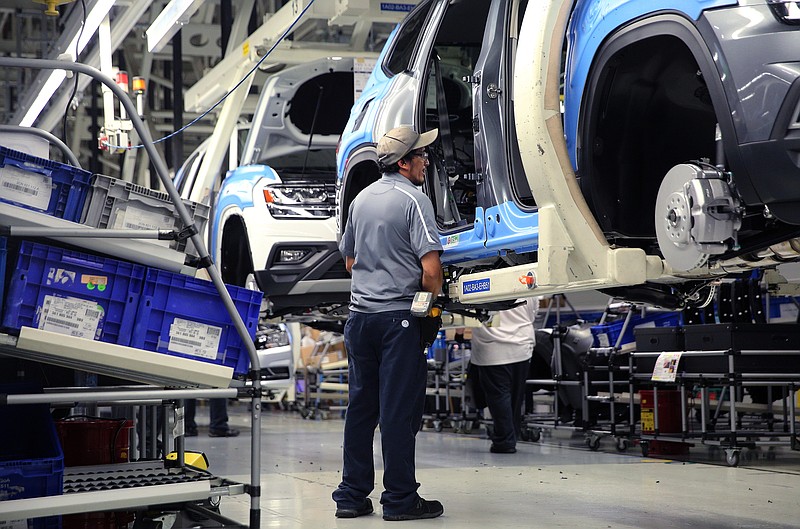 Staff file photo / A Volkswagen employee checks out vehicles moving down the assembly line at the company's Chattanooga assembly plant.