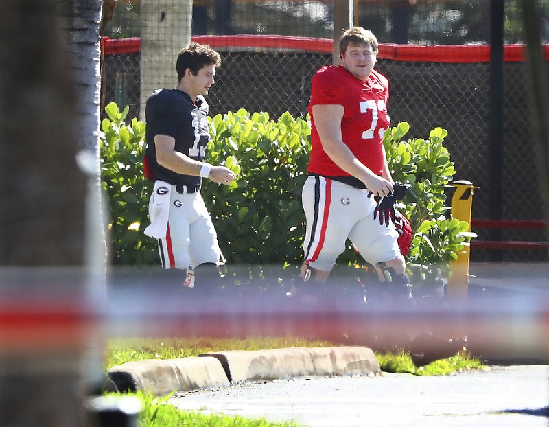  Georgia quarterback Stetson Bennett (left) and offensive lineman Xavier Truss walk to team practice for the Orange Bowl at Barry University on Monday, Dec. 27, 2021, in Miami Shores, Fla. Georgia plays Michigan at 7:30 p.m. on Friday at Hard Rock Stadium in Miami Gardens, Fla., in the Orange Bowl CFP Semifinal. (Curtis Compton/Atlanta Journal-Constitution via AP)