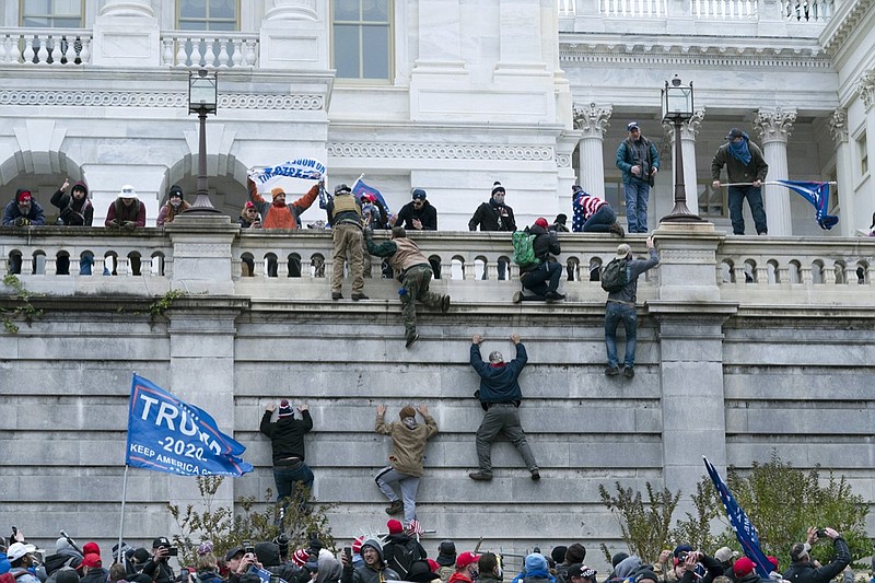 FILE - Violent insurrectionists loyal to then President Donald Trump climb the west wall of the the U.S. Capitol in Washington, Jan. 6, 2021. The House committee investigating the Jan. 6 insurrection at the Capitol has agreed to defer its request for hundreds of pages of records from the Trump administration, bending to the wishes of the Biden White House. (AP Photo/Jose Luis Magana, File)

