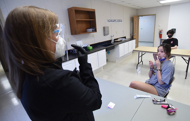 Staff Photo by Matt Hamilton / Nurse practitioner Anna Smartt, left, talks to students Isabella Puncochar and Matthew Stocks about how to self-administer the nasal swab at the testing center at University of Tennessee at Chattanooga on Wednesday, March 10, 2021.