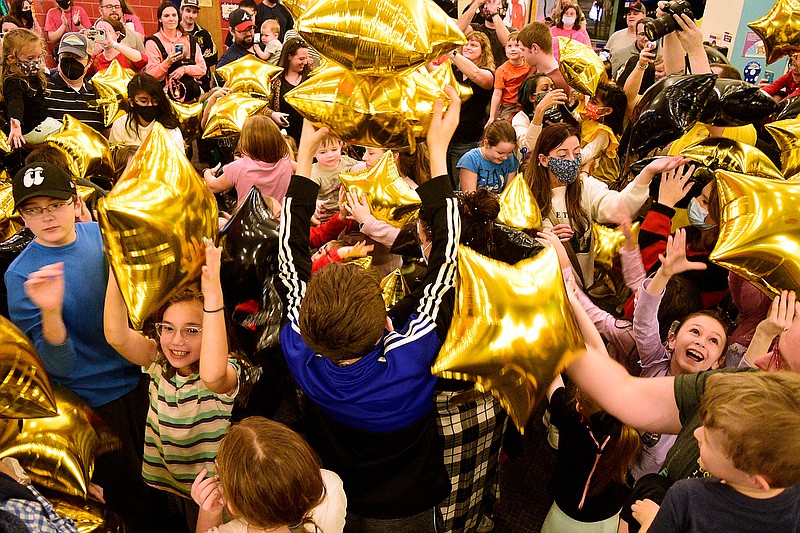Staff Photo by Robin Rudd / Black and gold balloons fall on the children as the New Year is celebrated. The New Year was celebrated during the "Cheers for the New Year" event at the Creative Discovery Museum on December 30, 2021.
