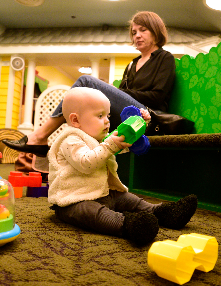 Staff Photo by Robin Rudd / Eight-month old Sunny DeYoung plays with blocks as Aunt Jenny Market looks on. The New Year was celebrated during the "Cheers for the New Year" event at the Creative Discovery Museum on December 30, 2021.