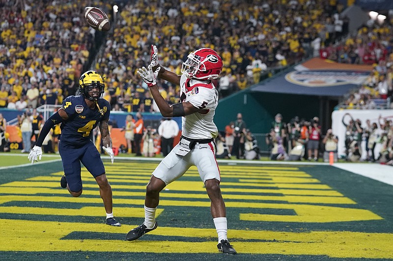 AP photo by Lynne Sladky / Georgia wide receiver Adonai Mitchell catches a touchdown pass behind Michigan defensive back Vincent Gray during the first half of the Orange Bowl semifinal Friday night in Miami Gardens, Fla.