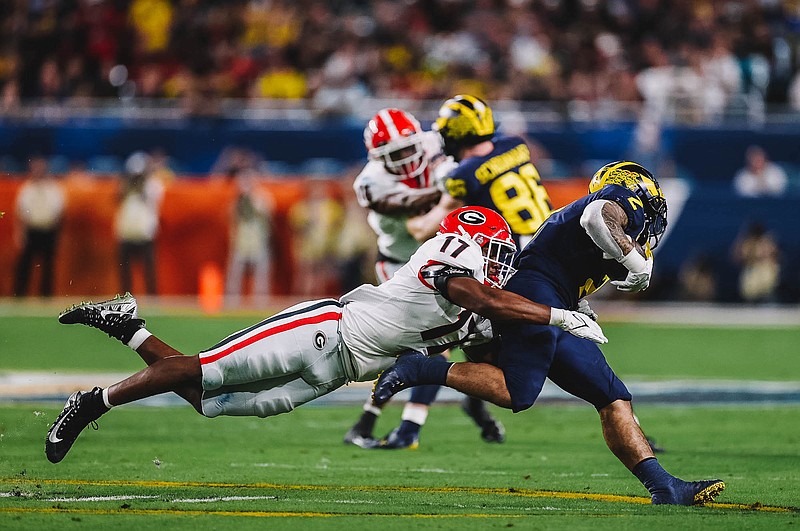 University of Georgia photo / Georgia inside linebacker Nakobe Dean wraps up Michigan's Blake Corum for a lost-yardage stop during Friday night's 34-11 Orange Bowl win. The Bulldogs will face Alabama for the national championship on Jan. 10.