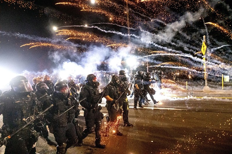 FILE - In this Sept. 5, 2020, file photo, police use chemical irritants and crowd control munitions to disperse protesters during a demonstration in Portland, Ore. (AP Photo/Noah Berger, File)


