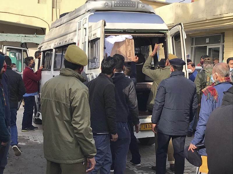 Policemen help to load coffin of a victim of a stampede from community health centre in Katra, near Jammu, India, Jan.1, 2022. (AP Photograph/Channi Anand)

