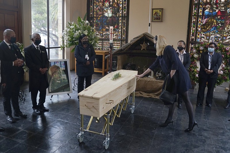 A mourner touches the coffin of Anglican Archbishop Emeritus Desmond Tutu during his funeral at the St. George's Cathedral in Cape Town, South Africa, Saturday, Jan. 1, 2022. (Nic Bothma/Pool via AP)

