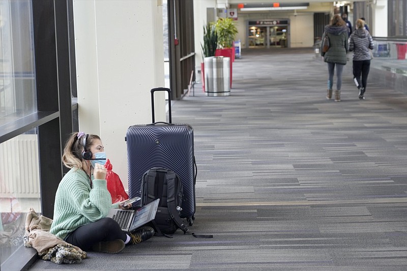 Katelyn Darrow gets some work done on her laptop as she waits to board her flight at the Philadelphia International Airport Friday, Dec. 31, 2021, in Philadelphia. (AP Photo/Michael Perez)


