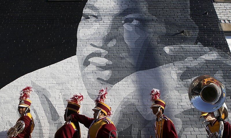 Staff photo by C.B. Schmelter / Members of the Howard School marching band walk past a mural of Martin Luther King Jr. while lining up for a memorial parade and march along M.L. King Boulevard on Monday, Jan. 15, 2018, in Chattanooga, Tenn.