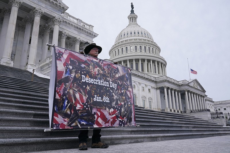 Photo by Susan Walsh of The Associated Press / Stephen Parloto of Boulder, Colo., holds a sign on Capitol Hill in Washington on Wednesday, Jan. 5, 2022, ahead of the one year anniversary of the Jan. 6 insurrection.