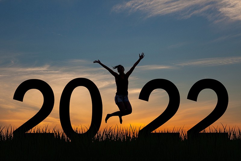 Silhouette of a woman jumping in 2022 on the hill at sunrise, New Year's resolutions. / 
