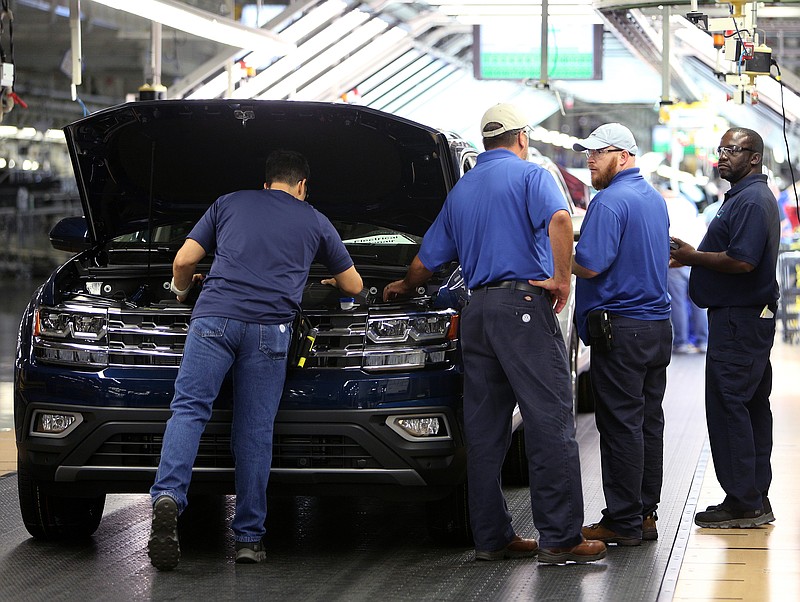 Staff file photo / Volkswagen employees check items under the hood of an Atlas SUV moving down the assembly line at the company's Chattanooga plant.