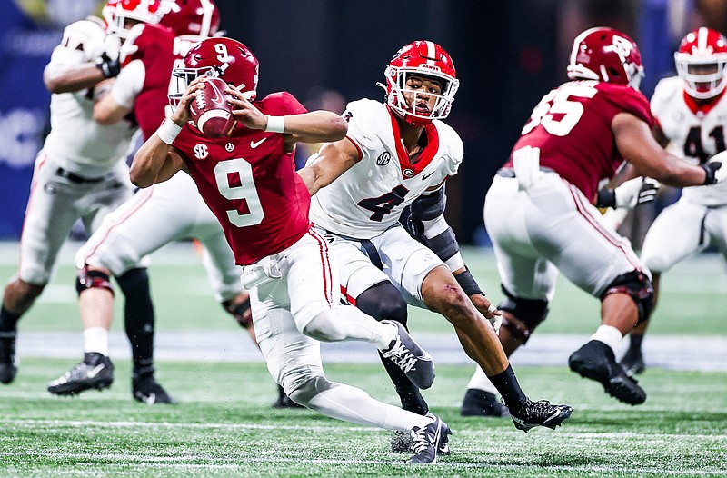 Georgia photo by Tony Walsh / Alabama quarterback Bryce Young eludes the pressure from Georgia junior outside linebacker Nolan Smith during last month's 41-24 win by the Crimson Tide at the Southeastern Conference championship game in Atlanta. The two programs will vie again Monday night in Indianapolis for the national title, with the Bulldogs seeking to end their 41-year drought.