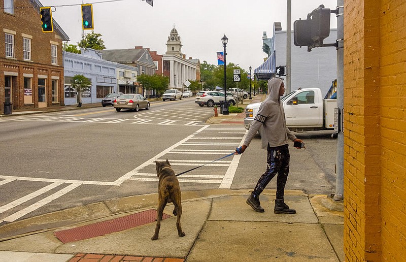 Amariel Yehudah walks his dog Draco in downtown Sparta. Yehudah was shocked to learn his community was a coronavirus hotspot. / Grant Blankenship, GPB News