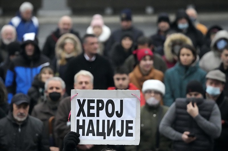 A supporter of Serbia's Novak Djokovic holds a banner that reads: ''National hero'' during a protest in Belgrade, Serbia, Saturday, Jan. 8, 2022. The No. 1-ranked Djokovic was denied entry at the Melbourne airport late Wednesday after border officials canceled his visa for failing to meet its entry requirement that all non-citizens be fully vaccinated for COVID-19. (AP Photo/Darko Vojinovic)