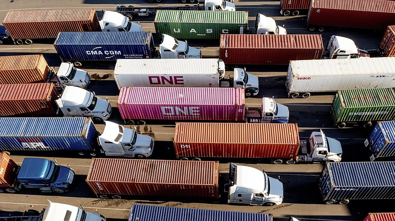 FILE - Trucks line up to enter a Port of Oakland shipping terminal on Nov. 10, 2021, in Oakland, Calif. The pandemic has receded as a top priority in many voters' minds to start 2022, with the economy overshadowing coronavirus concerns and worries about inflation on the rise, a poll from The Associated Press-NORC Center for Public Affairs Research finds. (AP Photo/Noah Berger, File)