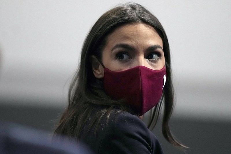 FILE - U.S. Rep. Alexandria Ocasio-Cortez looks round to listen to a question at the COP26 U.N. Climate Summit, in Glasgow, Scotland, Wednesday, Nov. 10, 2021. Ocasio-Cortez has tested positive for COVID-19 and "is experiencing symptoms and recovering at home," her office said in a statement Sunday, Jan. 9, 2022. (AP Photo/Alastair Grant, File)