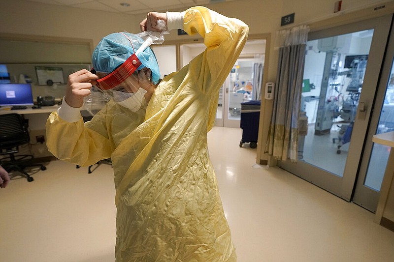 Registered nurse Sara Nystrom, of Townshend, Vt., prepares to enter a patient's room in the COVID-19 Intensive Care Unit at Dartmouth-Hitchcock Medical Center, in Lebanon, N.H., Jan. 3, 2022. The omicron variant has caused a surge of new cases of COVID-19 in the U.S. and many hospitals are not only swamped with cases but severely shorthanded because of so many employees out with COVID-19. (AP Photo/Steven Senne, File)