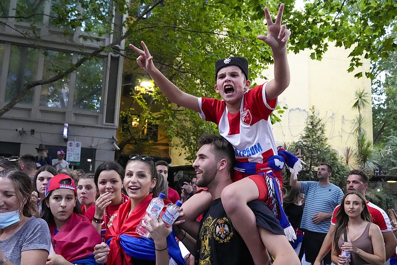 Fans cheer outside an immigration detention hotel where Serbian tennis star Novak Djokovic is confined in Melbourne, Australia, Monday, Jan. 10, 2022. An Australian judge who will decide whether top-ranked tennis star Novak Djokovic plays in the Australian Open has questioned what more the Serbian could have done to meet Australia's coronavirus entry requirements. (AP Photo/Mark Baker)