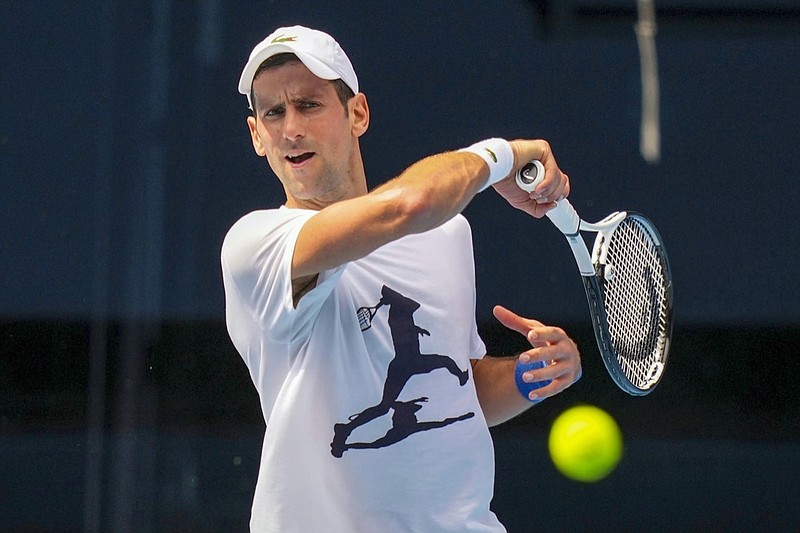 In this photo supplied by Tennis Australia, defending champion Serbia's Novak Djokovic practices in the Rod Laver Arena ahead of the Australian Open at Melbourne Park in Melbourne, Australia, Tuesday, Jan. 11, 2022. The prime ministers of Australia and Serbia have discussed Novak Djokovic's precarious visa after the top-ranked Serbian tennis star won a court battle to compete in the Australian Open but still faces the threat of deportation because he is not vaccinated against COVID-19. (Scott Barbour/Tennis Australia via AP)