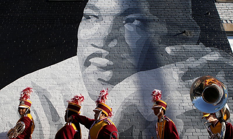 Staff file photo / Members of the Howard School marching band walk past a mural of Martin Luther King Jr. while lining up for a memorial parade and march along M.L. King Boulevard in 2018.