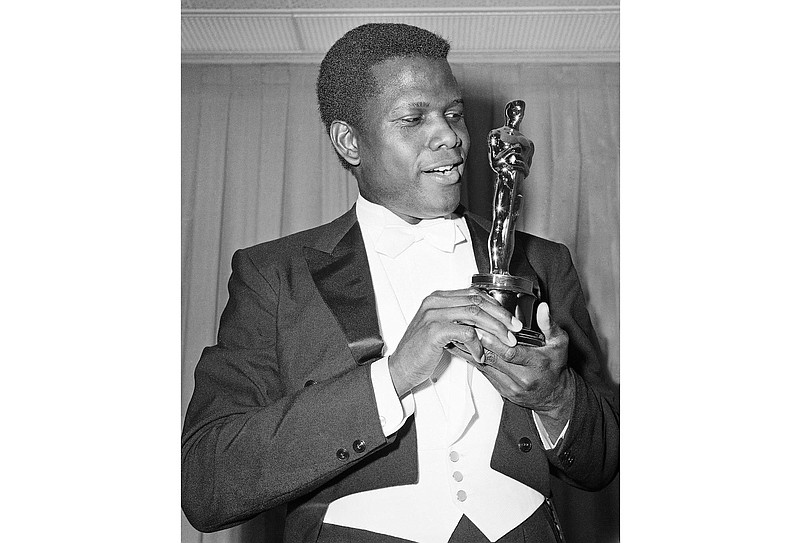 File photo from The Associated Press / Actor Sidney Poitier is photographed with his Oscar statuette at the 36th Annual Academy Awards in Santa Monica, Calif., on April 13, 1964. He won Best Actor for his role in "Lillies of the Field."