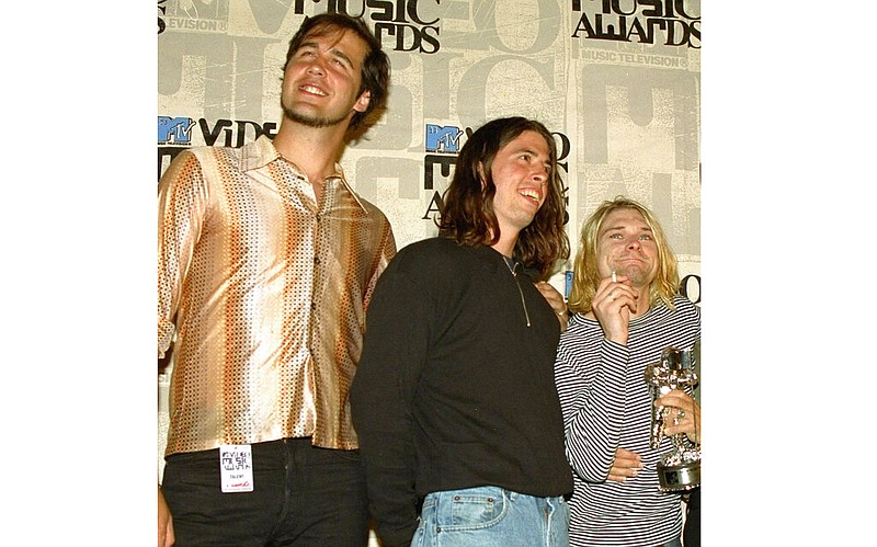 Nirvana band members, from left, Krist Novoselic, Dave Grohl and Kurt Cobain pose after receiving an award for best alternative video at the 10th annual MTV Video Music Awards in Universal City, Calif., on Sept. 2, 1993. A federal judge has dismissed the lawsuit of a 30-year-old man who alleged that the image of him nude as a baby on the 1991 cover of Nirvana's "Nevermind" is child pornography. Judge Fernando Olguin granted the motion by Nirvana's attorneys to dismiss the case Monday, Jan. 3, 2022 but said plaintiff Spencer Elden can refile an amended version of the suit. (AP Photo/Mark J. Terrill, File)