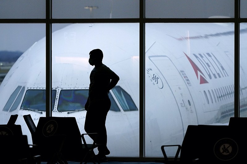 FILE - A passenger wears a face mask to help prevent the spread of the new coronavirus as he waits for a Delta Airlines flight at Hartsfield-Jackson International Airport in Atlanta on Feb. 18, 2021. (AP Photo/Charlie Riedel, File)


