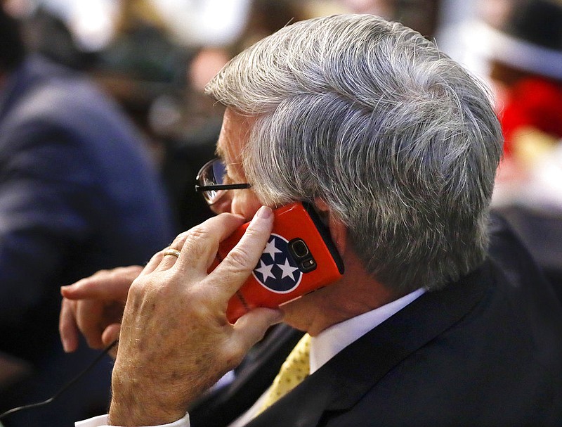 Sen. Todd Gardenhire, R-Chattanooga, talks on a phone with a Tennessee flag cover during a Senate session Wednesday, May 10, 2017, in Nashville, Tenn. (AP Photo/Mark Humphrey)