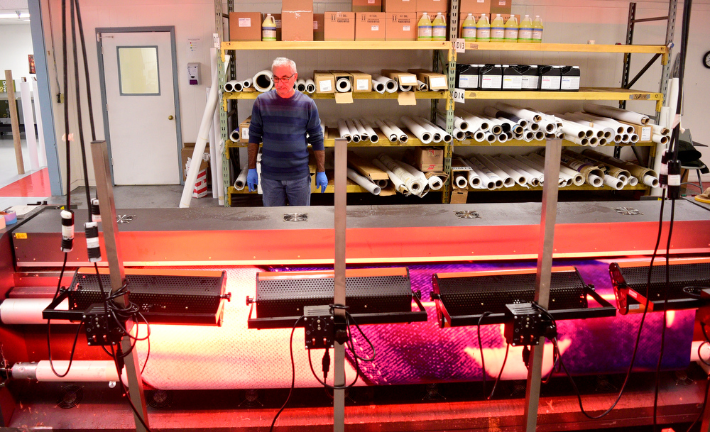 Staff Photo by Robin Rudd / Azad Amen monitors the printing of a large piece of advertising. Vincent Printing, formed in 1940, and located in East Chattanooga, is one of the country's biggest print shops of its type. New owner. Beau Wells talked with the newspaper on January 13, 2022.