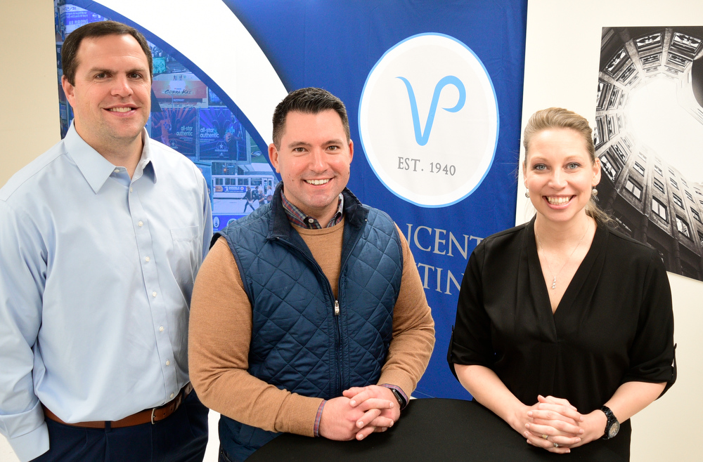 Staff Photo by Robin Rudd / From left, Bo Freeland, Business Development Strategist for Sports and Entertainment Development, Beau Wells, Owner, and Karah Plagens, Senior Account and Communications Manager pose for a photo in the company's East Chattanooga offices. Vincent Printing, formed in 1940, and located in East Chattanooga, is one of the country's biggest print shops of its type. New owner. Beau Wells talked with the newspaper on January 13, 2022.